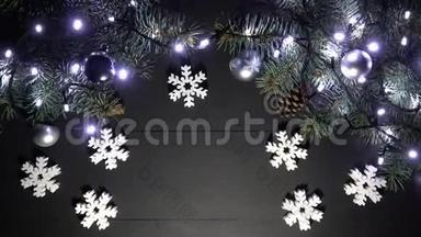 在黑色木桌上摆放着云杉树枝、模糊的闪烁<strong>灯光</strong>、<strong>圣诞</strong>球和雪花玩具的<strong>圣诞</strong>边框